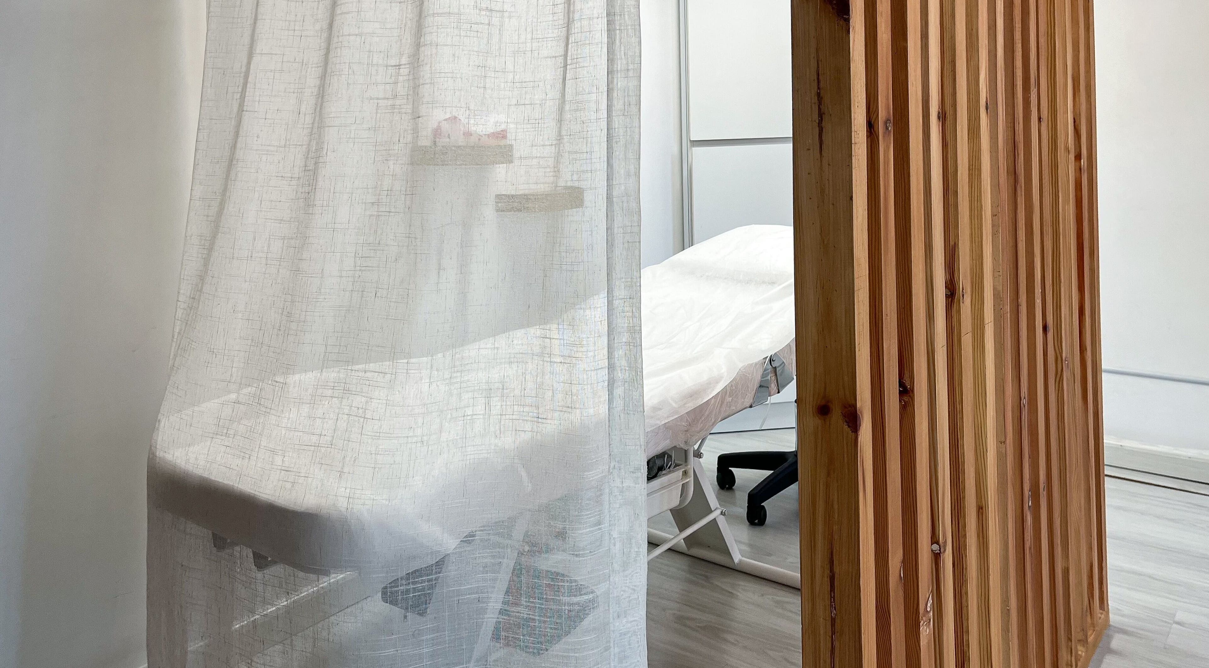 Relaxing treatment room at Mona Beauty in Jeddah, Makkah Province, SA, with soft curtains and a comfy massage table.