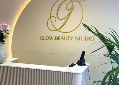 Reception area at Glow Beauty Studio in Guernsey, Saint Peter Port, GG with floral arrangements and logo.