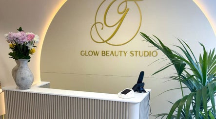Reception area at Glow Beauty Studio in Guernsey, Saint Peter Port, GG with floral arrangements and logo.