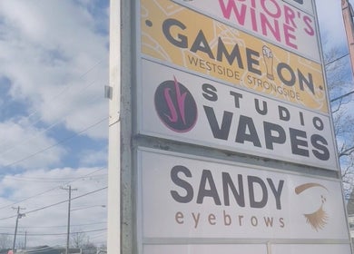 Outdoor signage for Sandy Eyebrows, a beauty venue in Cincinnati, Ohio, US, on a sunny day.