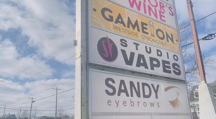 Outdoor signage for Sandy Eyebrows, a beauty venue in Cincinnati, Ohio, US, on a sunny day.