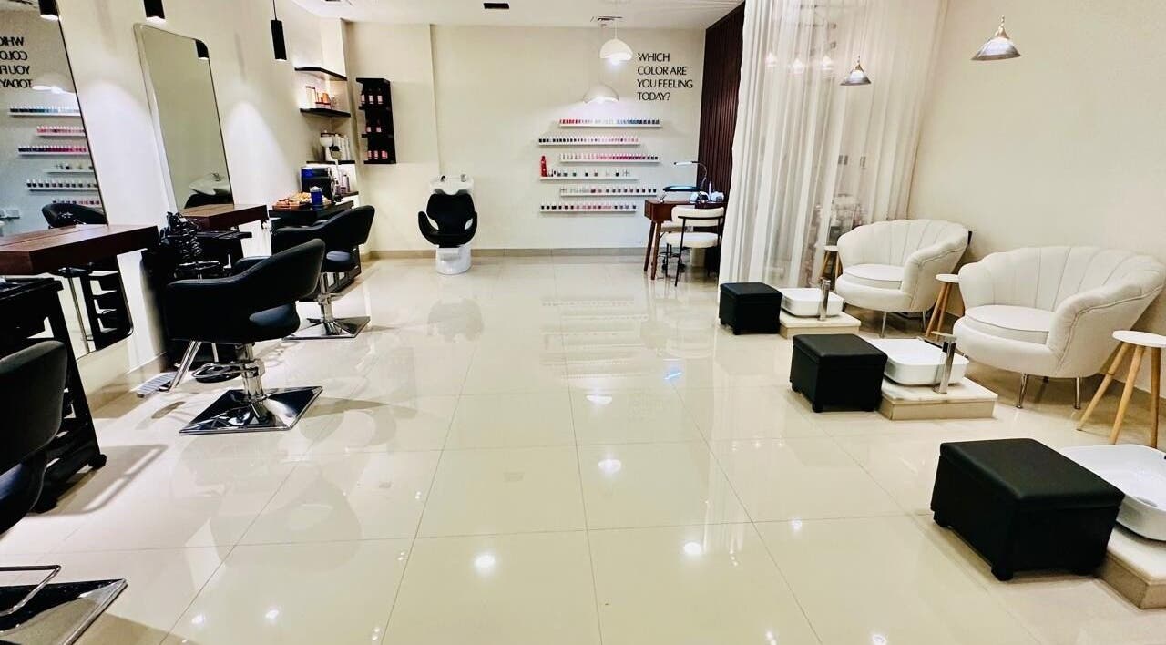 Chic interior of Braid Beauty Center's salon in Sharjah, Sharjah, AE, featuring modern styling chairs and nail stations.