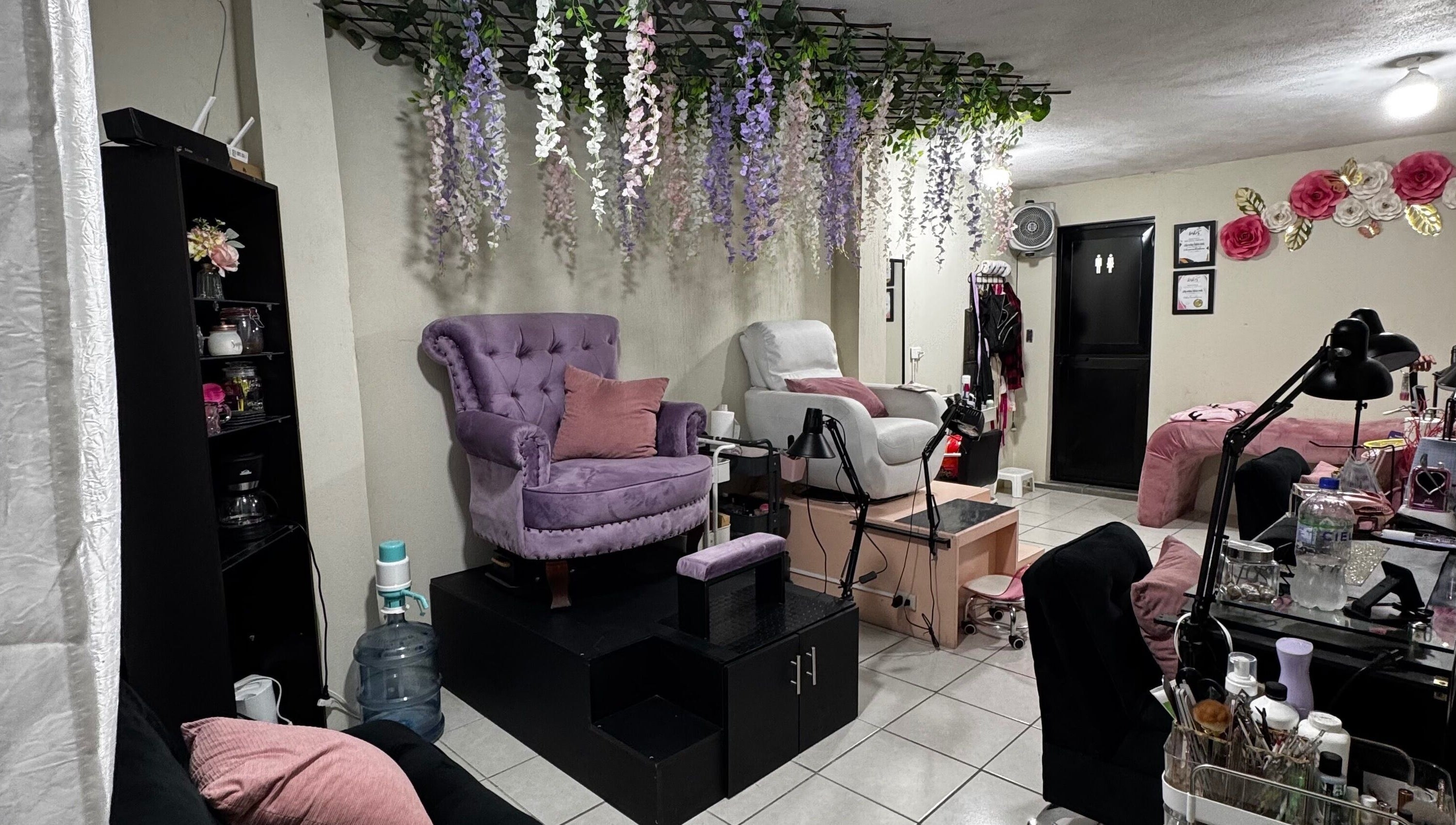 Interior de Nails Studio en Ciudad De Guatemala, Guatemala, GT, con sillas elegantes y decoración floral.