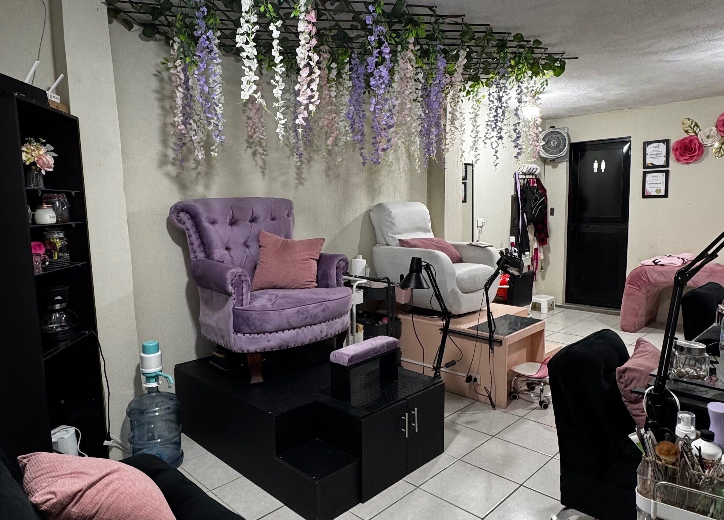 Interior de Nails Studio en Ciudad De Guatemala, Guatemala, GT, con sillas elegantes y decoración floral.