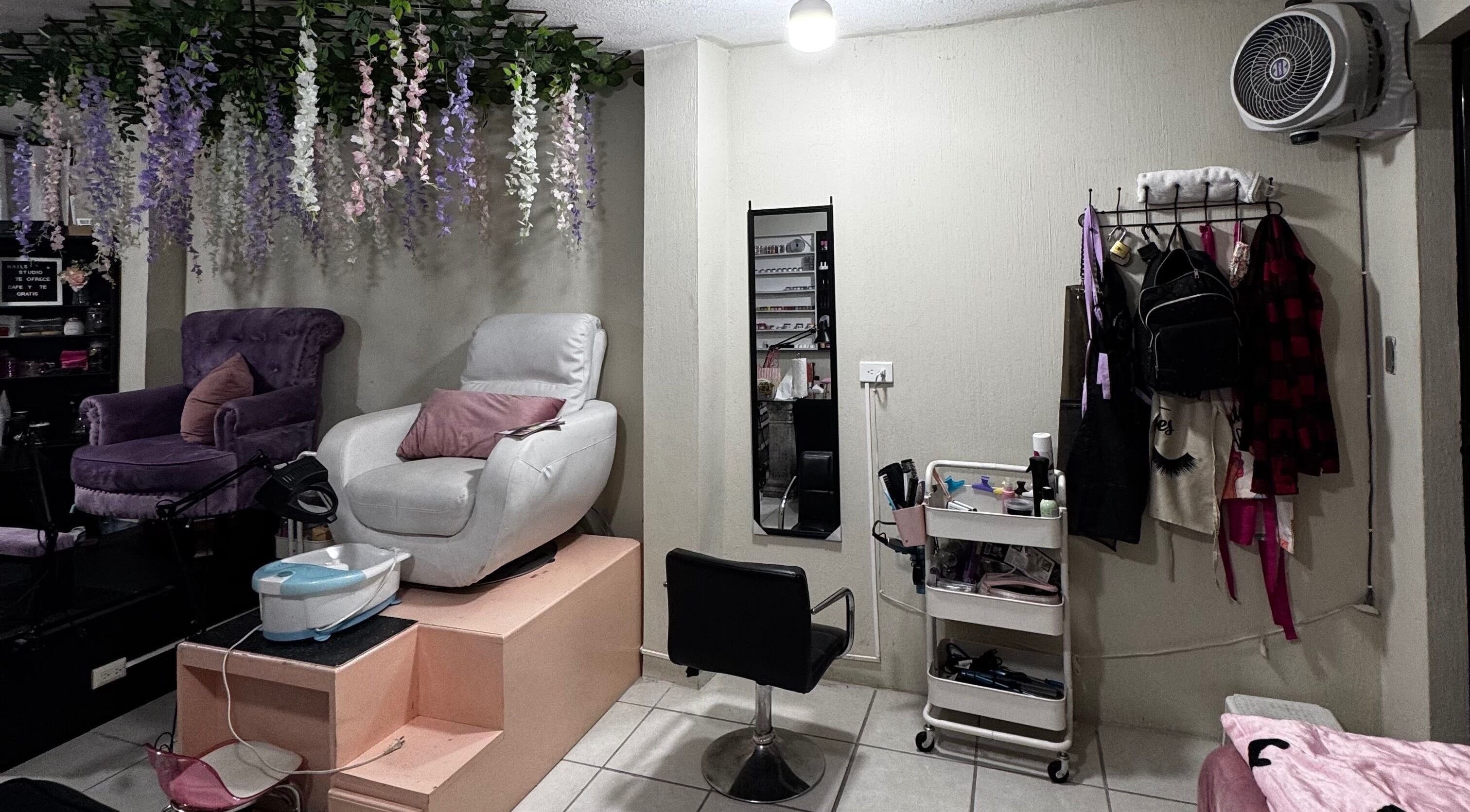 Nails Studio en Ciudad De Guatemala, Guatemala, GT, presenta sillas cómodas y decoración floral elegante.