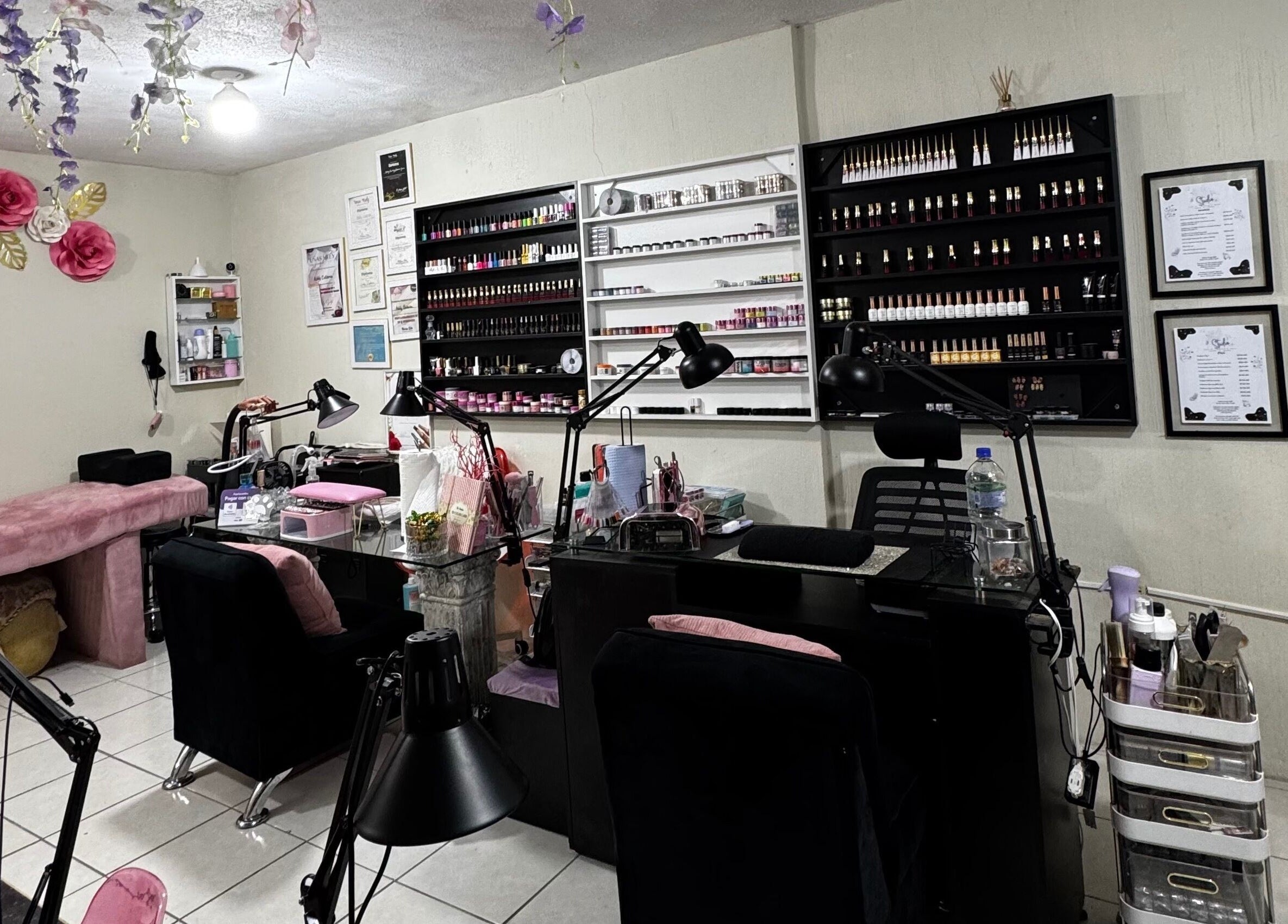 Interior de Nails Studio en Ciudad De Guatemala, Guatemala, GT, con decoración floral rosa y estaciones de manicura.