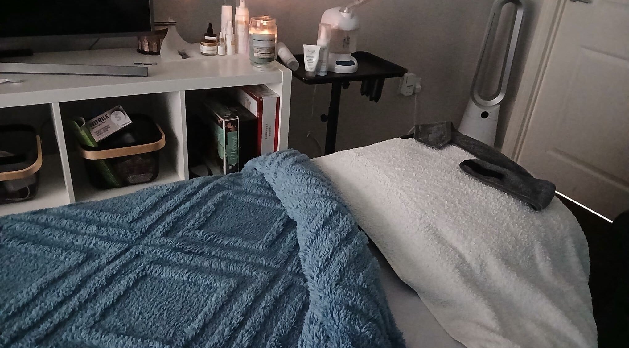 Relaxing treatment room at The Spa Treatment Therapies, Halifax, England, GB, with candles and plush towels.