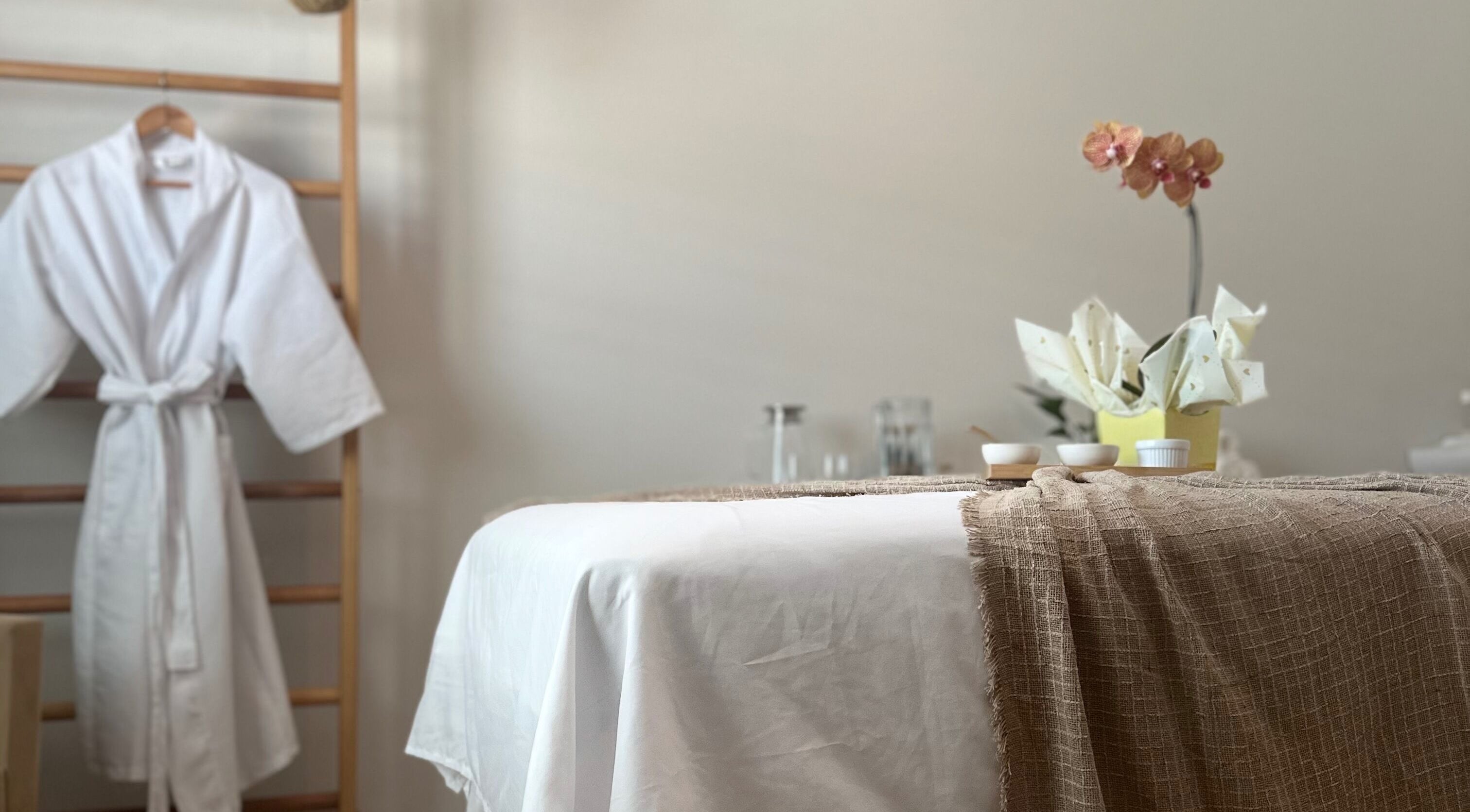 Ambiente de relaxamento com mesa de massagem e roupão em Terapias de SPA - Heloisy Coleta, São Paulo, BR.