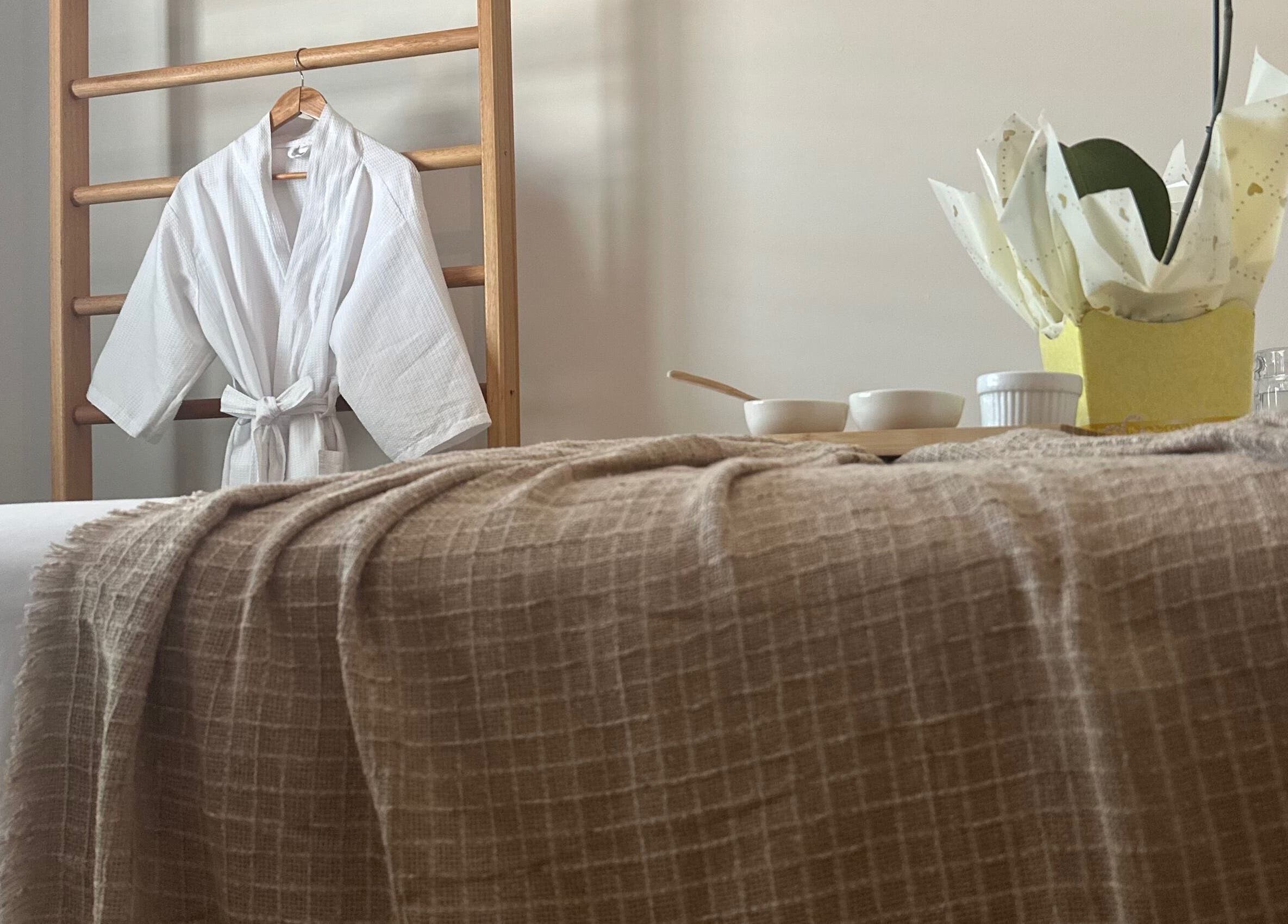 Sala de spa com roupão e mesa de terapia em Terapias de SPA - Heloisy Coleta, São Paulo, São Paulo, BR.
