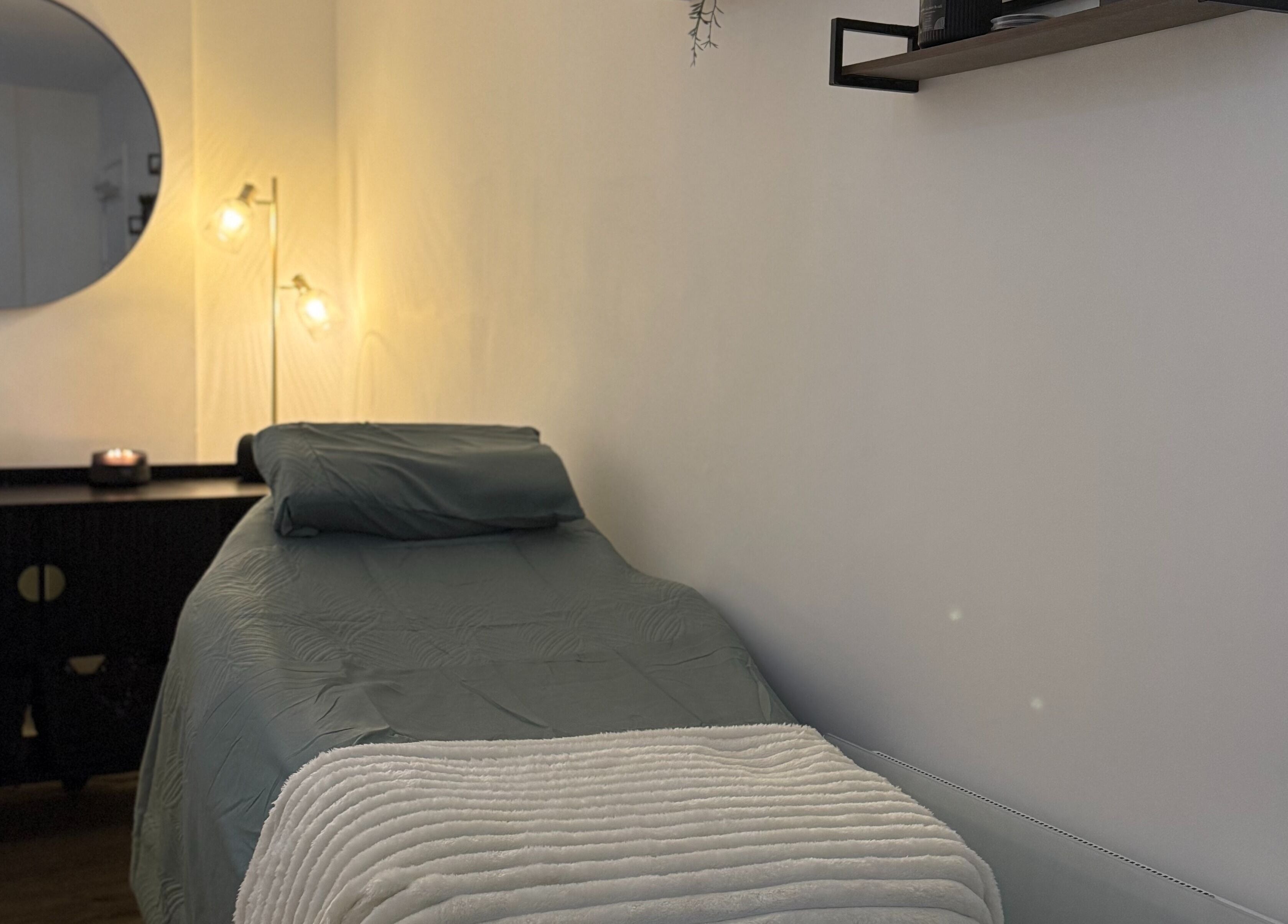 Relaxing treatment room at Beauty by Gonzàlez, West Bridgford, England, GB, with soft lighting and cozy bed.