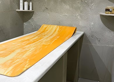Relaxing treatment room at Ambra Beauty, Abu Dhabi, AE, featuring a soothing massage table with orange accents.