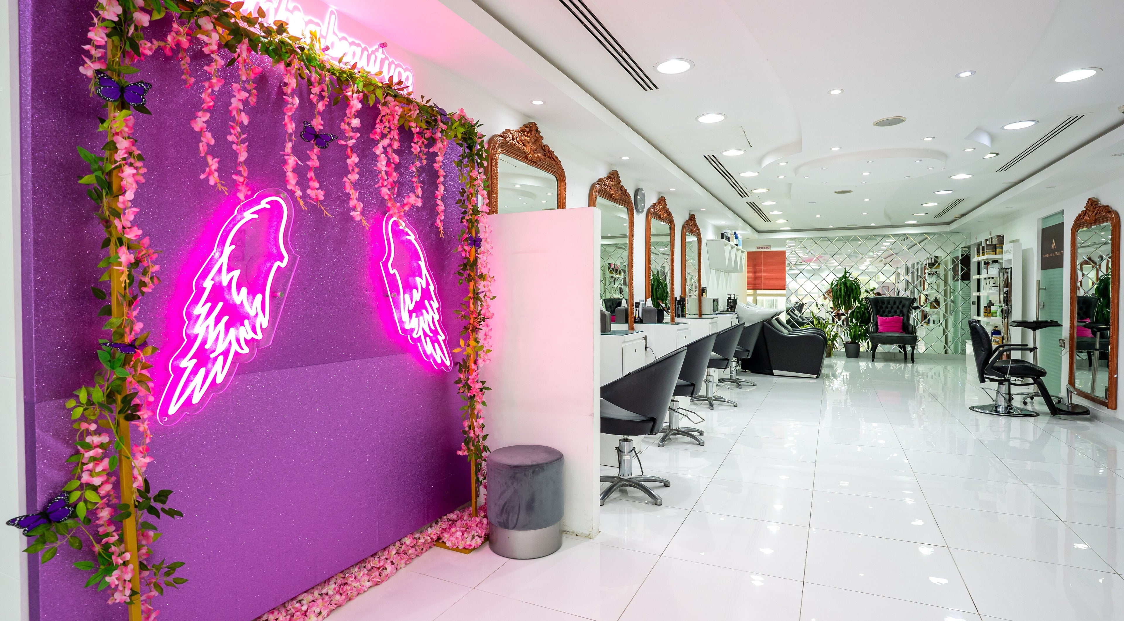 Modern salon interior at Ambra Beauty, Abu Dhabi, AE with neon accents and elegant decor.