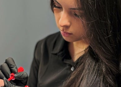 Técnica aplica esmalte rojo en Cari Nails, Pooler, Georgia, US. Atención al detalle en cada servicio.