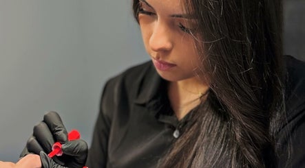 Técnica aplica esmalte rojo en Cari Nails, Pooler, Georgia, US. Atención al detalle en cada servicio.