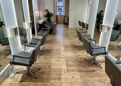 Chic interior of Erin Hunt Hairdressing, Edinburgh, Scotland, GB, featuring modern salon chairs on polished wood floors.