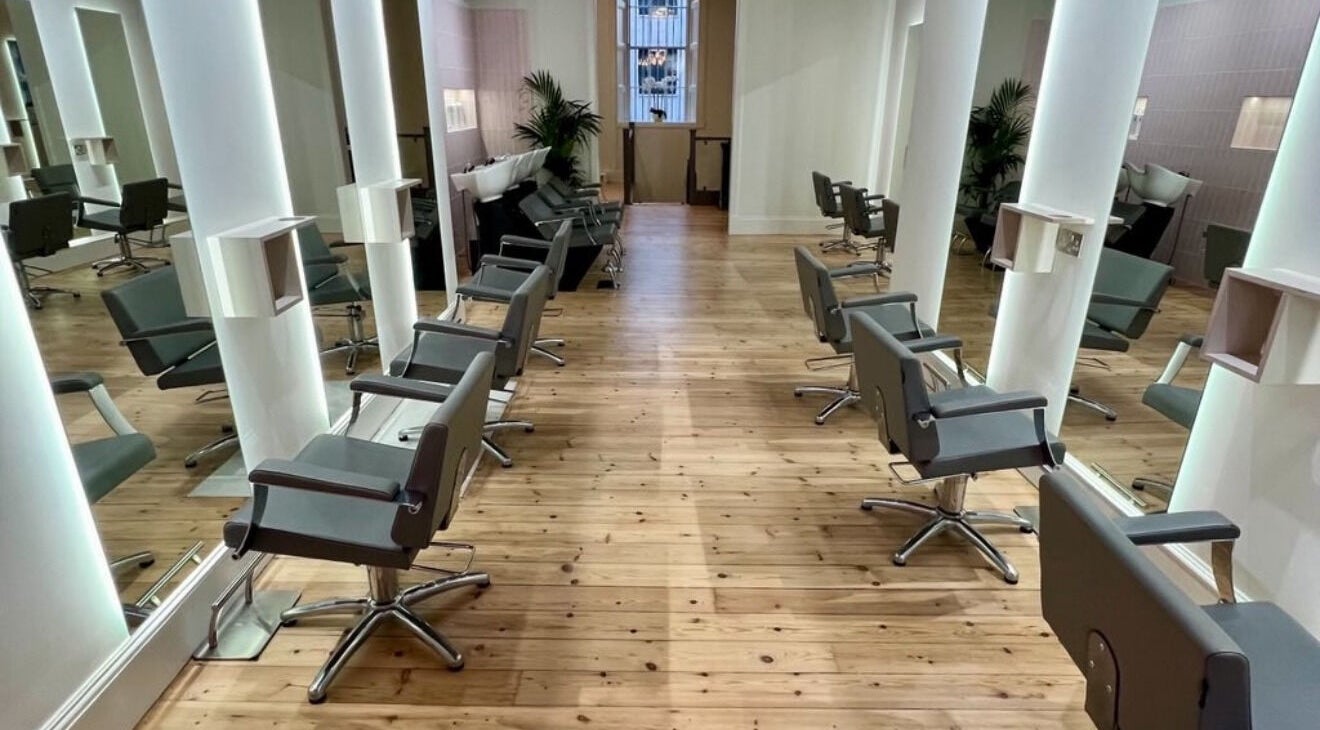 Modern interior of Erin Hunt Hairdressing, a sleek salon in Edinburgh, Scotland, GB with stylish chairs and mirrors.