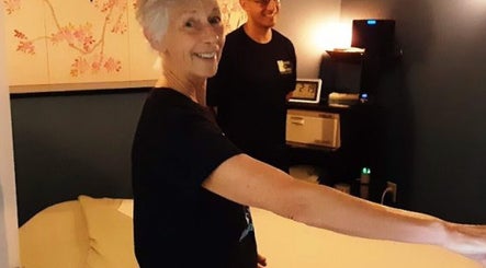 Smiling staff at Body in Mind Massage Institute - Toms River, New Jersey, US in a cozy treatment room.