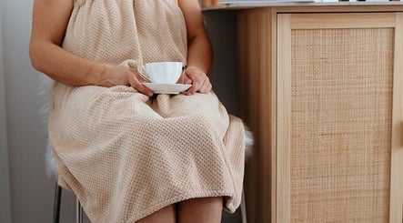 Client enjoying tea at Flourish Skin & Beauty, Wānaka, Otago, NZ, promoting relaxation and pampering.