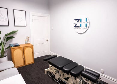 Modern treatment room at Zenova Healthcare Chiropractic, Auckland, NZ with black massage table and minimalist decor.