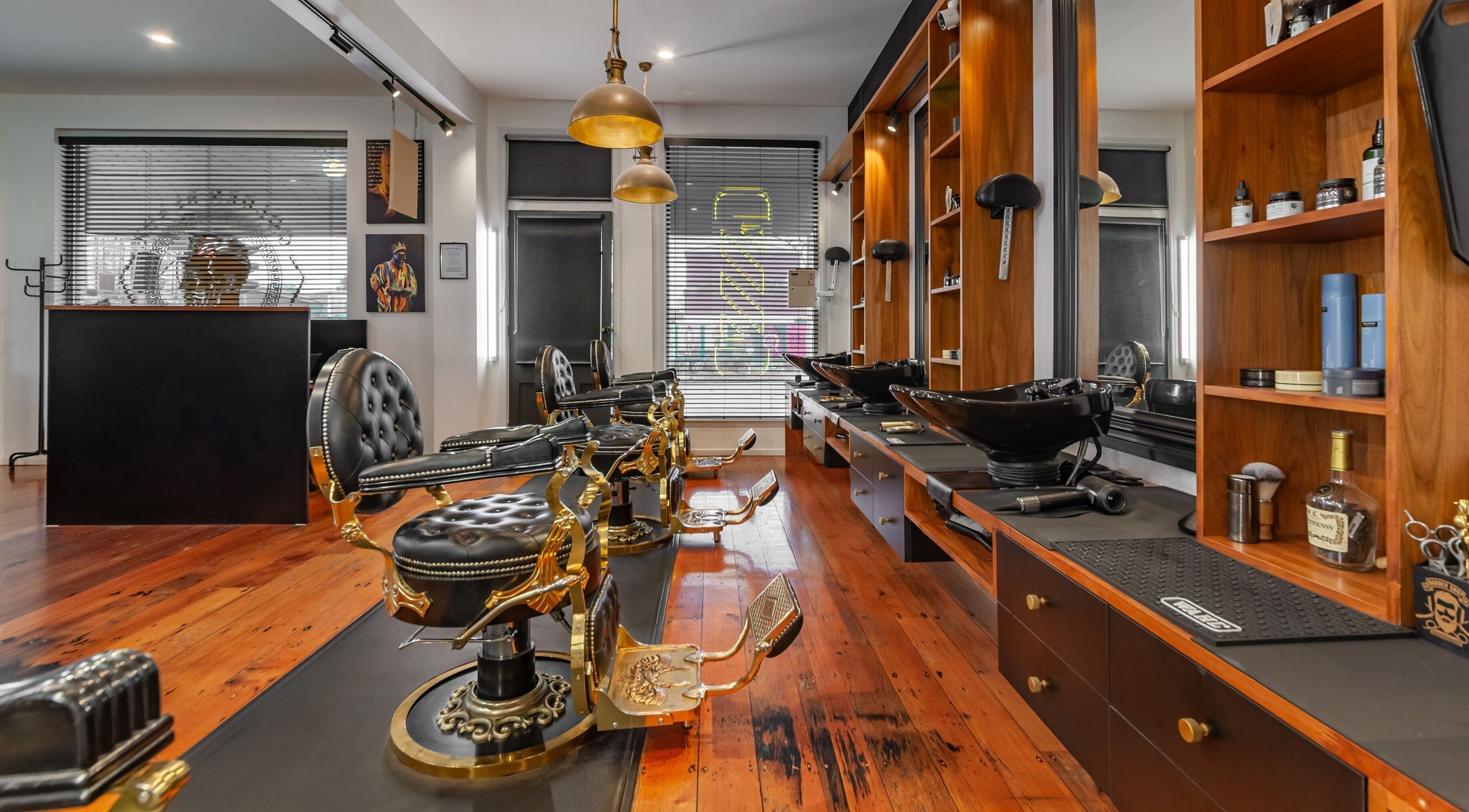 Luxurious interior of Golden Blade Barber Lounge in Christchurch, Canterbury, NZ with stylish chairs and wooden decor.