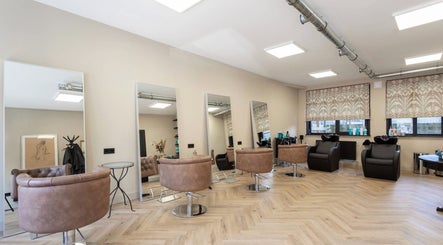 Stijlvol interieur van Salon Zuid in Amsterdam, Noord-Holland, NL met moderne kappersstoelen en spiegels.