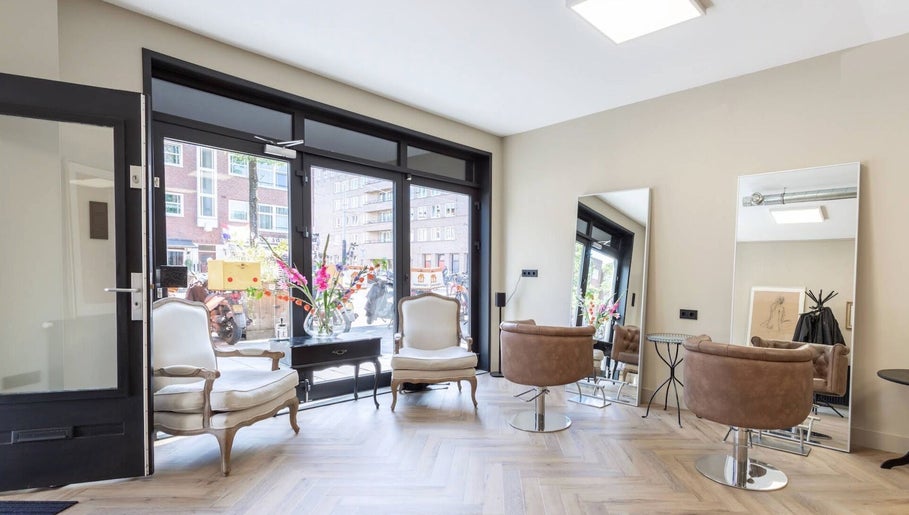 Elegant interieur van Salon Zuid in Amsterdam, Noord-Holland, NL met moderne stoelen en grote spiegels.