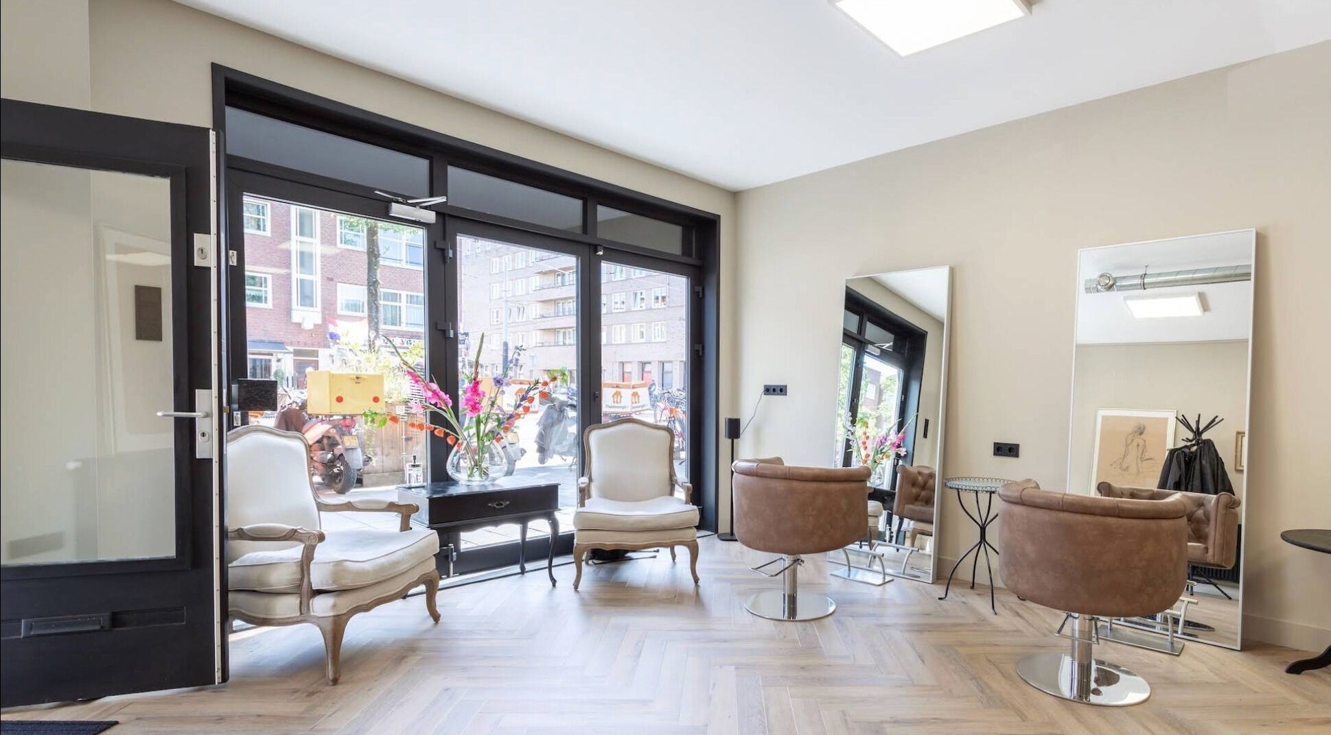 Elegant interieur van Salon Zuid in Amsterdam, Noord-Holland, NL met moderne stoelen en grote spiegels.