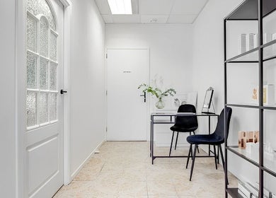 Stijlvolle witte ingang bij Charme Aesthetics in Utrecht, Utrecht, NL met moderne inrichting en producten.