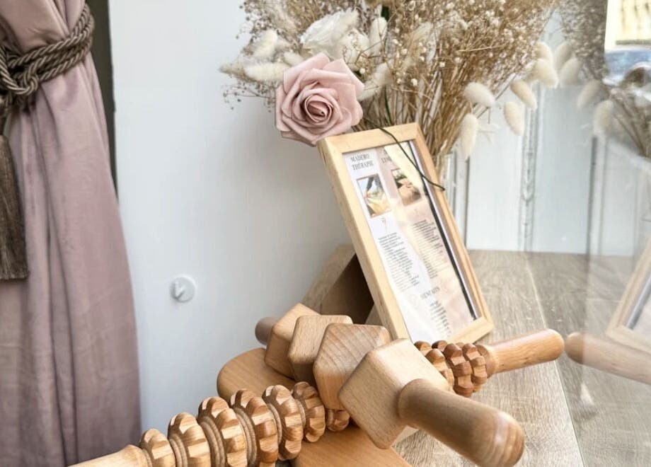 Elegant decor with pink rose and wooden massage tool at Institut Caramel Paris, Paris, Île-de-France, FR.