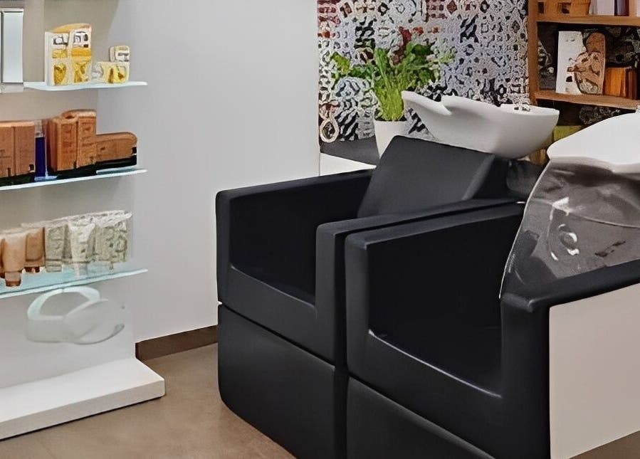 Zona de lavado en Magic Peluqueros, Sant Joan D'alacant, Comunidad Valenciana, ES, con sillas y productos de belleza.