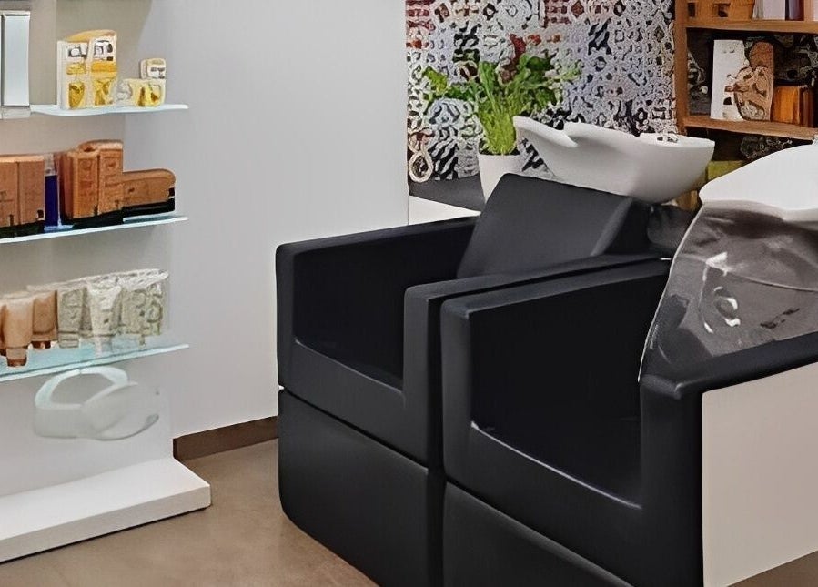 Zona de lavado en Magic Peluqueros, Sant Joan D'alacant, Comunidad Valenciana, ES, con sillas y productos de belleza.