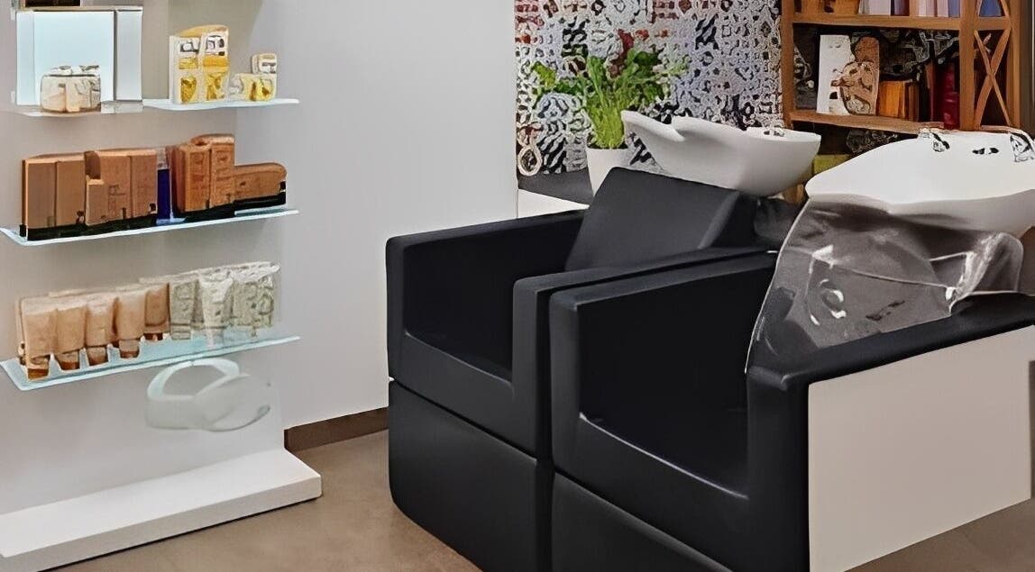 Zona de lavado en Magic Peluqueros, Sant Joan D'alacant, Comunidad Valenciana, ES, con sillas y productos de belleza.