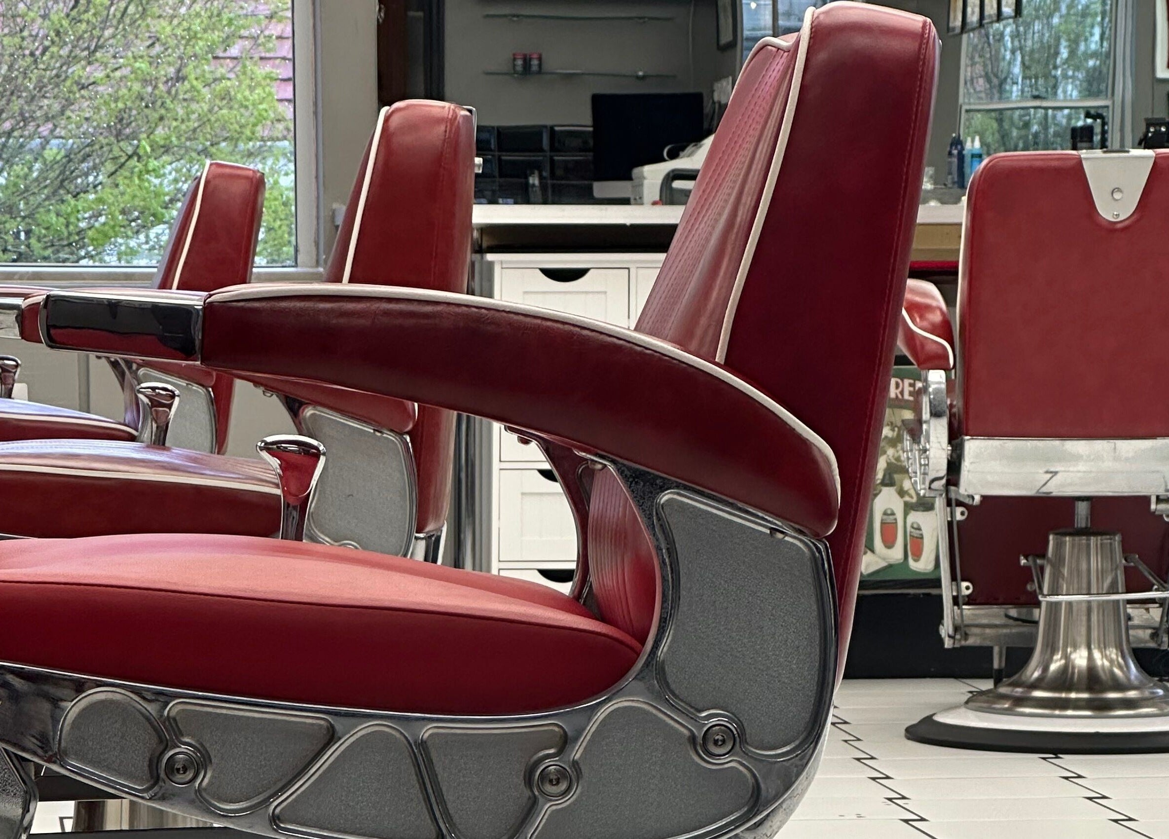 Classic red barber chairs at Image Barbers, Saint Helier, St Helier, JE create a retro ambiance.