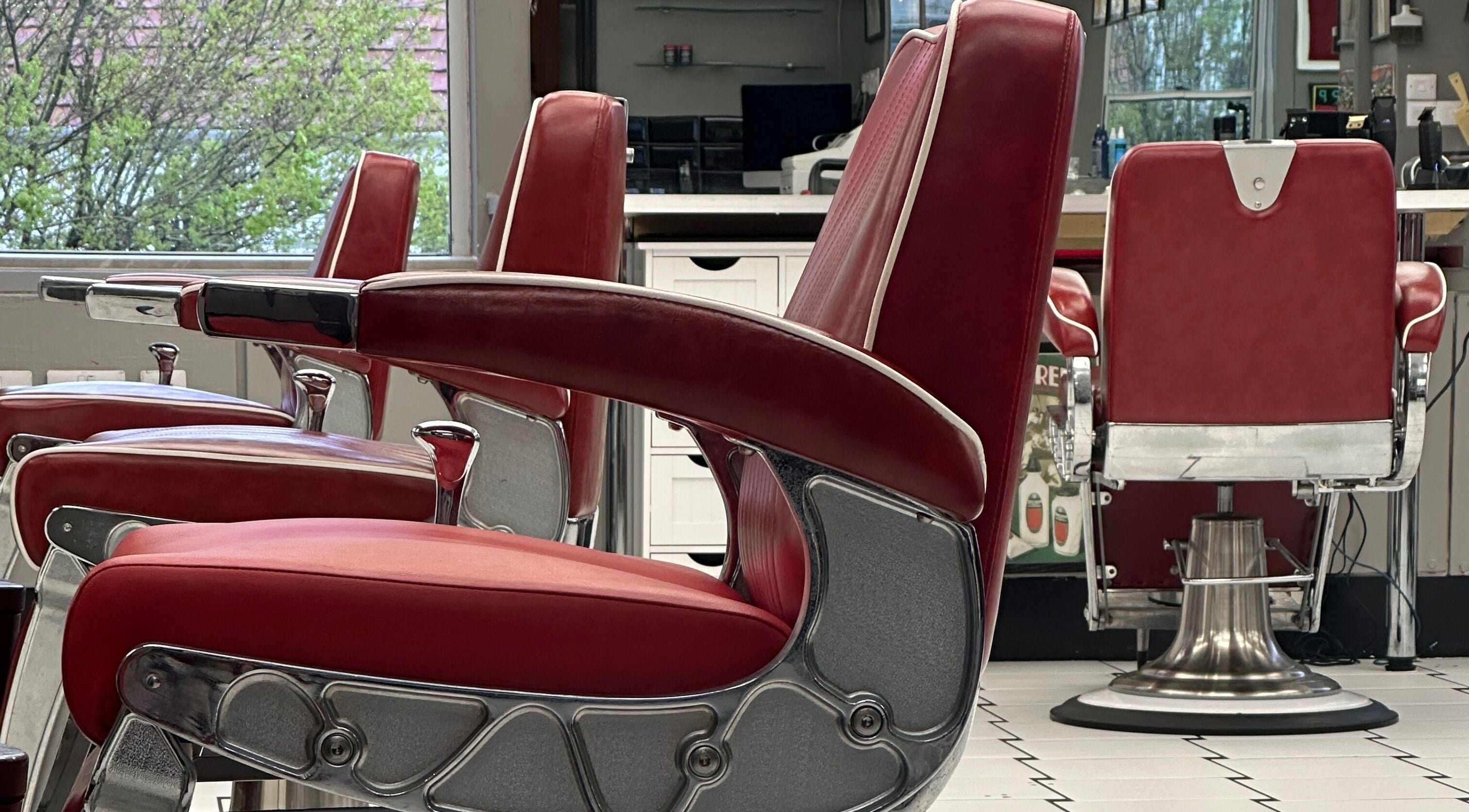 Classic red barber chairs at Image Barbers, Saint Helier, St Helier, JE create a retro ambiance.