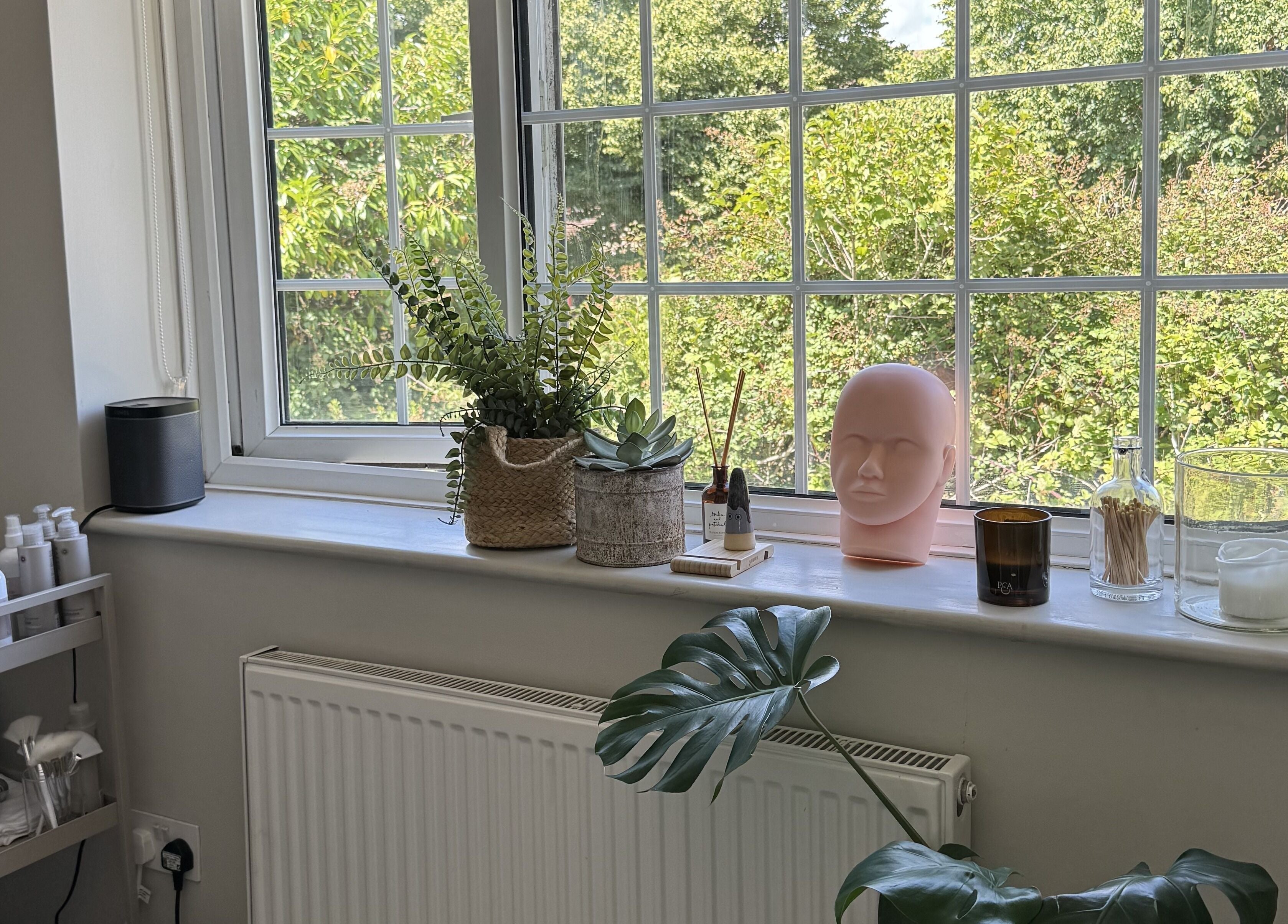 A calming window display with plants and candles at Solara Studio, Christchurch, GB.