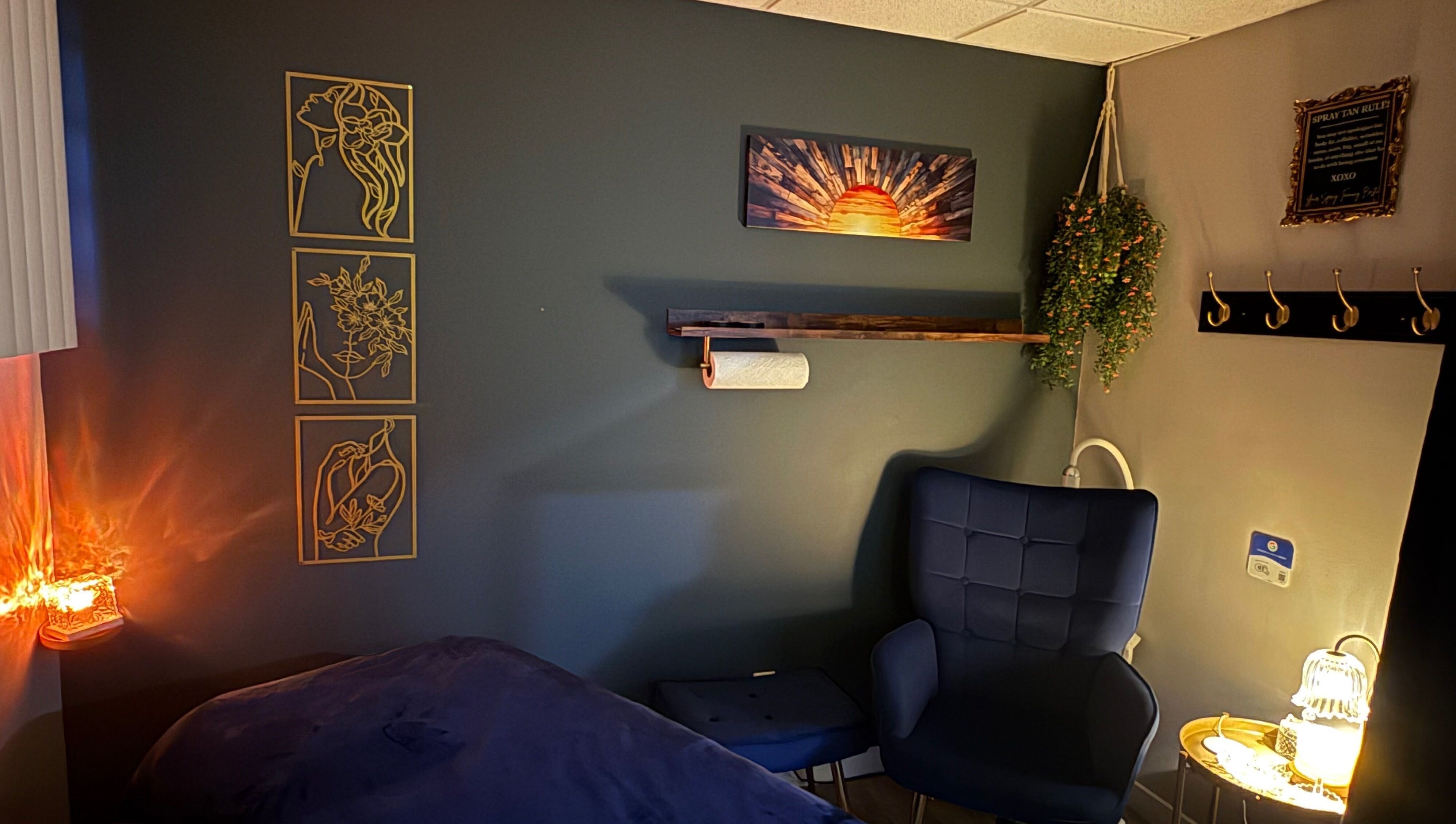 Chic treatment room at Sunkissed Luxe, Kenora, Ontario, CA, with cozy seating and artistic wall decor.