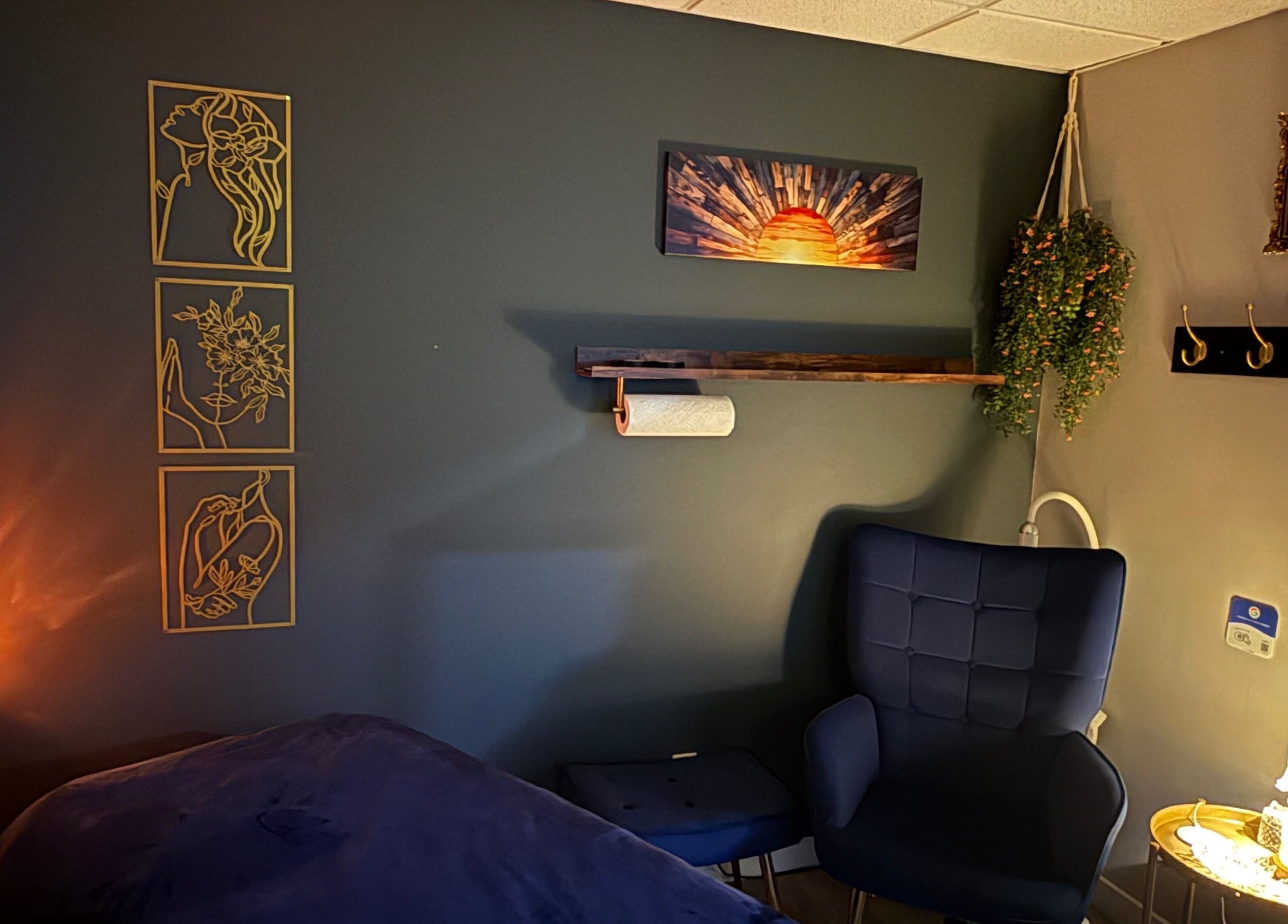 Chic treatment room at Sunkissed Luxe, Kenora, Ontario, CA, with cozy seating and artistic wall decor.