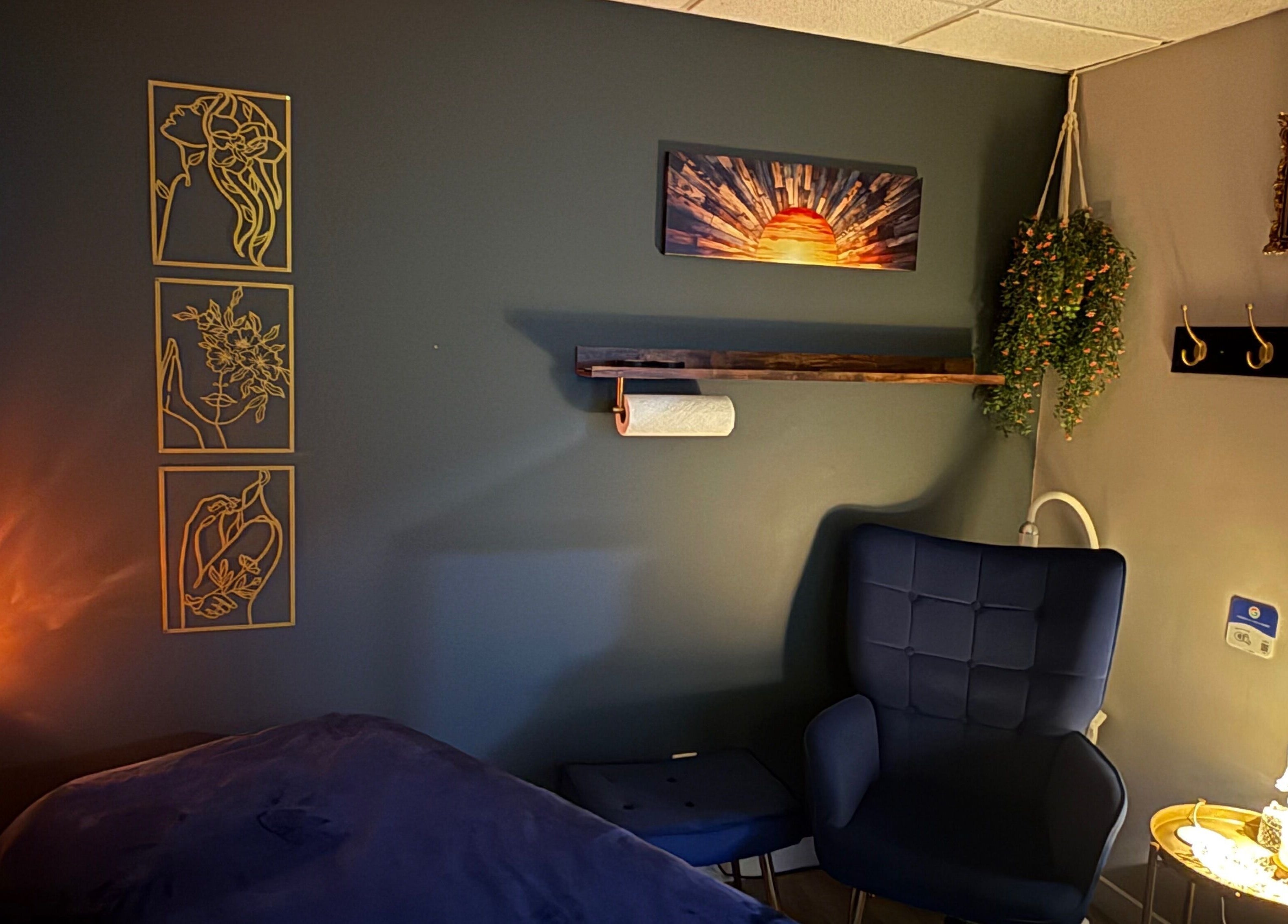Chic treatment room at Sunkissed Luxe, Kenora, Ontario, CA, with cozy seating and artistic wall decor.