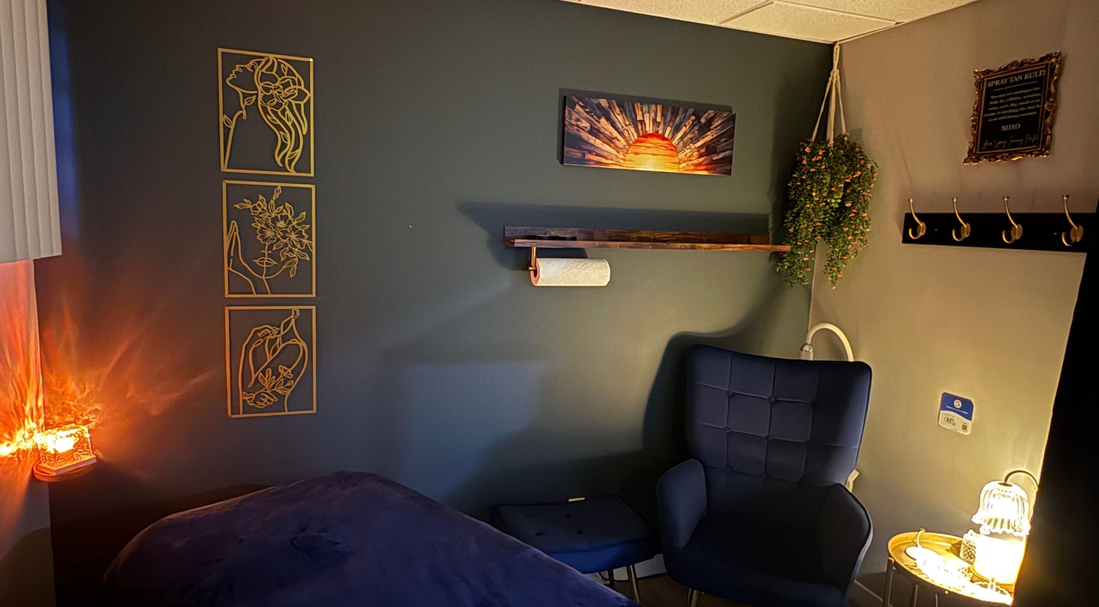 Chic treatment room at Sunkissed Luxe, Kenora, Ontario, CA, with cozy seating and artistic wall decor.