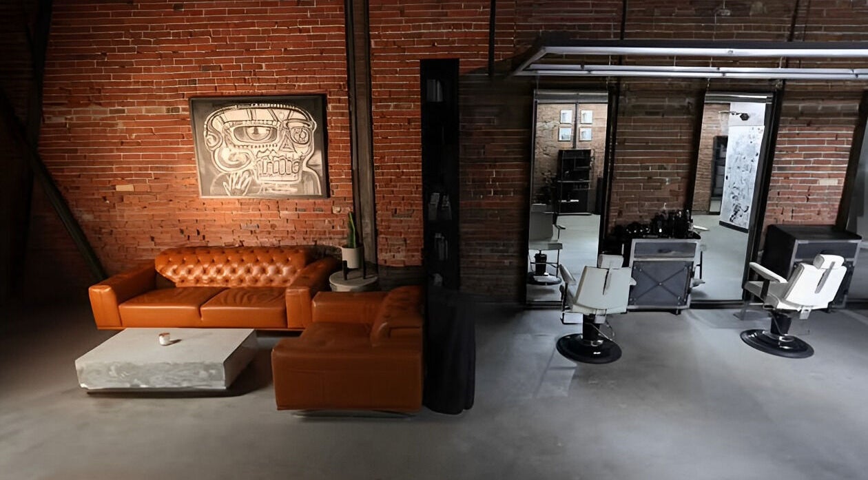 Chic interior of Xerxes Barber & Lounge in Vancouver, British Columbia. Cozy brown seating and modern barber chairs.