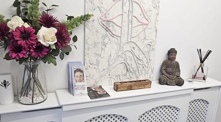 Aura 8 Mcr in Prestwich, England, GB: elegant Buddha statue and floral decor on a white mantle.
