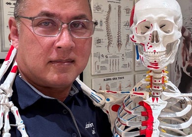 Instructor at The Rehabist, Singapore, SG, with a human skeleton model in a detailed anatomy lesson.