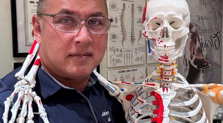 Instructor at The Rehabist, Singapore, SG, with a human skeleton model in a detailed anatomy lesson.