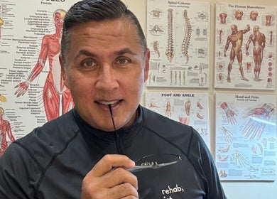 Expert at The Rehabist in Singapore, Singapore, SG, in front of anatomical charts, offering wellness consultations.