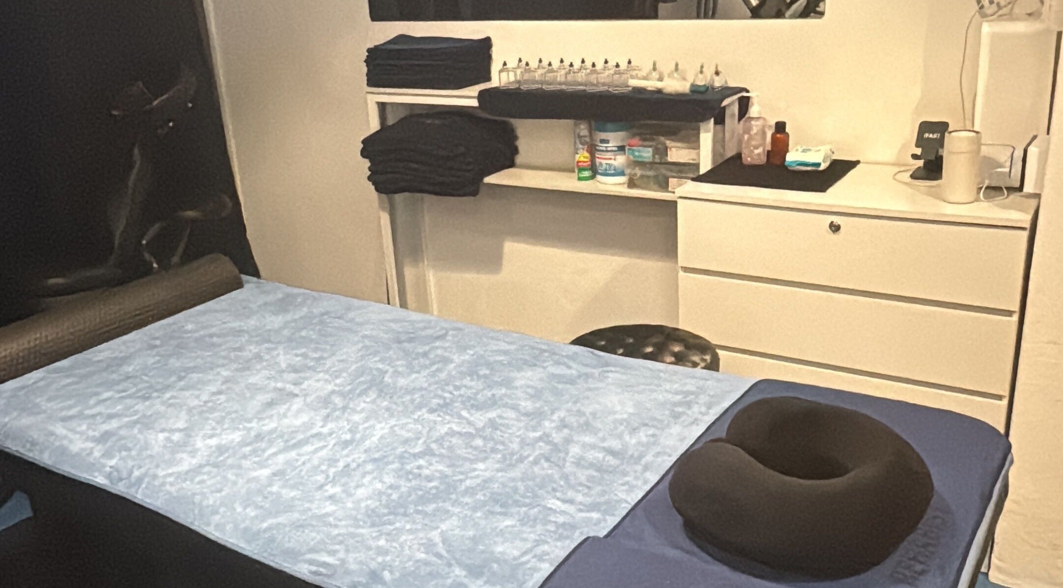 Relaxing treatment room at The Rehabist, Singapore, SG, featuring comfortable massage table and neat storage.