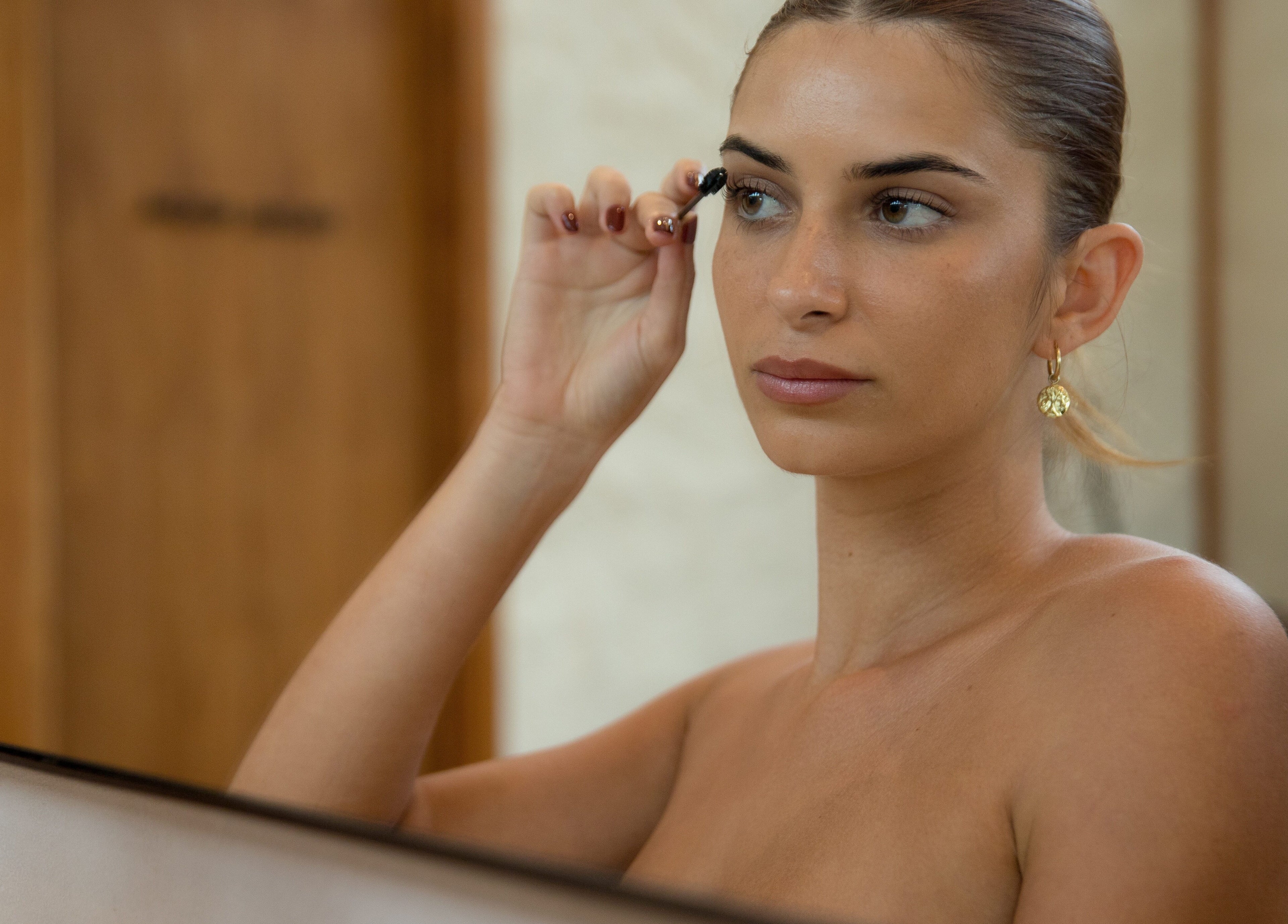 Woman applying makeup at Estetica Belle, Kabupaten Badung, Bali, ID. Experience serene beauty services.