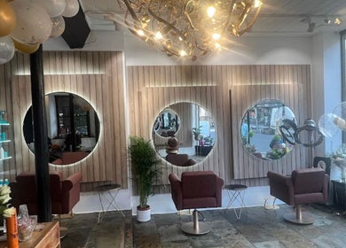 Chic salon interior at Saria Styles in Bristol, England, GB, featuring elegant mirrors and stylish seating.