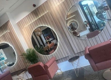 Modern salon interior at Saria Styles in Bristol, England, GB featuring elegant mirrors and plush seating.