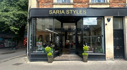 Saria Styles salon entrance in Bristol, England, GB, featuring elegant signage and sleek modern decor.