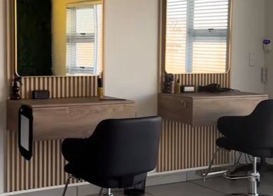 Modern styling stations at Just Glow Hair Studio, Cape Town, Western Cape, ZA, with sleek black chairs.